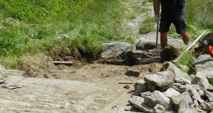 Die Steine aus der bestehenden Strasse wurden wieder verwendet. Ein Wassergraben auf der Hangseite dient der Entwässerung. Die Steine aus der bestehenden Strasse wurden wieder verwendet. Ein Wassergraben auf der Hangseite dient der Entwässerung.